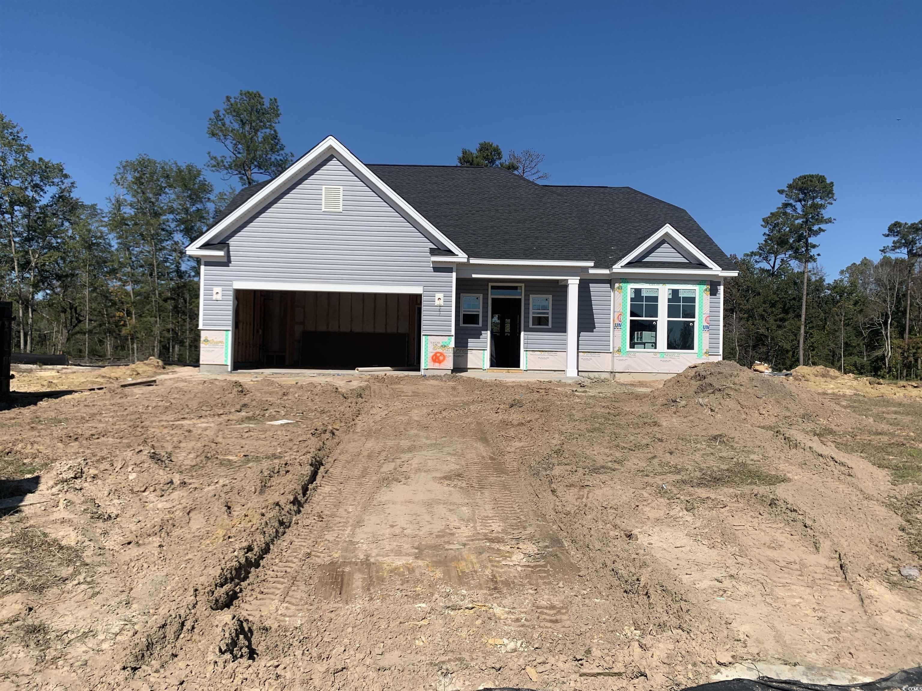 View of front facade featuring covered porch, driveway, and a shingled roof