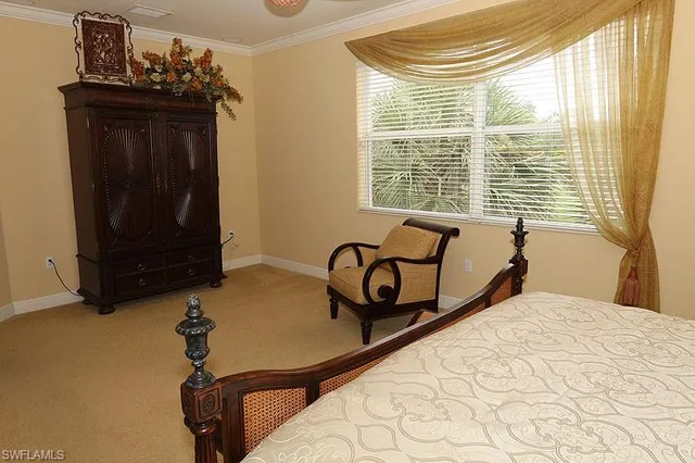 a bed sitting in a bedroom next to a window and dresser