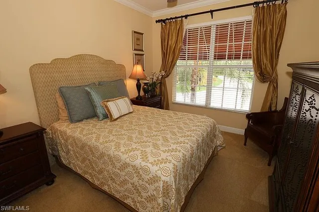 a bed sitting in a bedroom next to a window