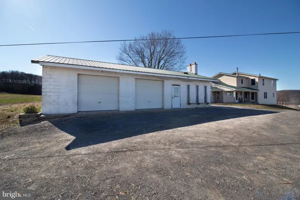 a view of a house with a yard and a forest