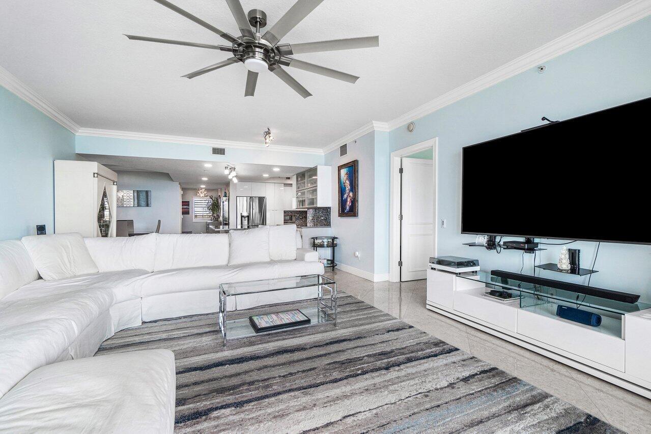 2650 Lake Shore Drive, Unit 701 Riviera Beach, FL 33404 - Photo 6 of 64 a living room with furniture and a flat screen tv