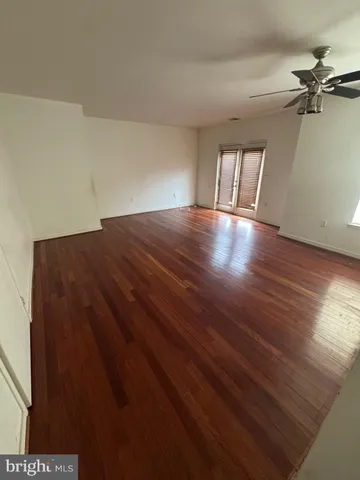 a view of a room with wooden floor and a ceiling fan