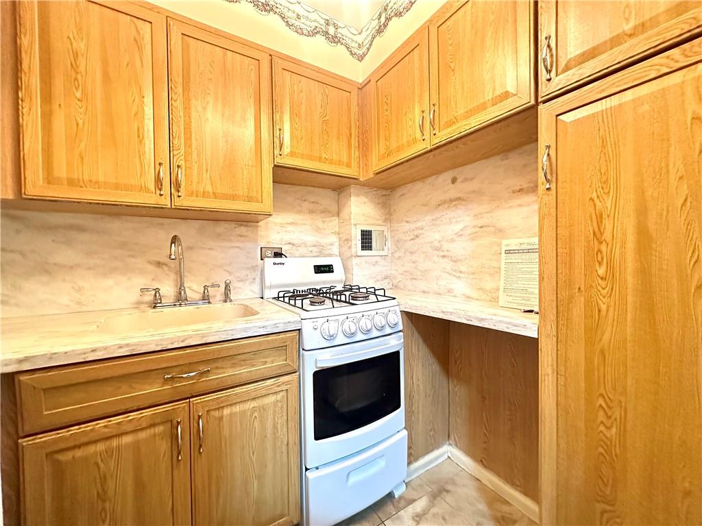 3060 Ocean Avenue, Unit 2C Brooklyn, NY 11235 - Photo 12 of 20 a kitchen with stainless steel appliances a stove a sink and cabinets