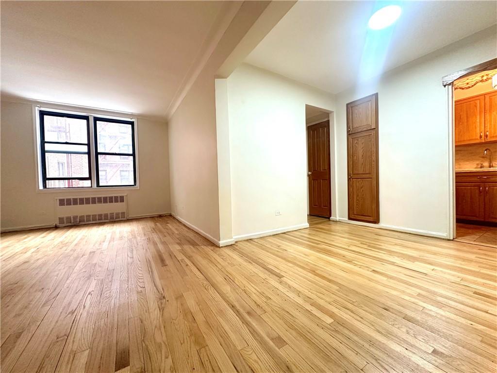 3060 Ocean Avenue, Unit 2C Brooklyn, NY 11235 - Photo 3 of 20 an empty room with wooden floor and windows