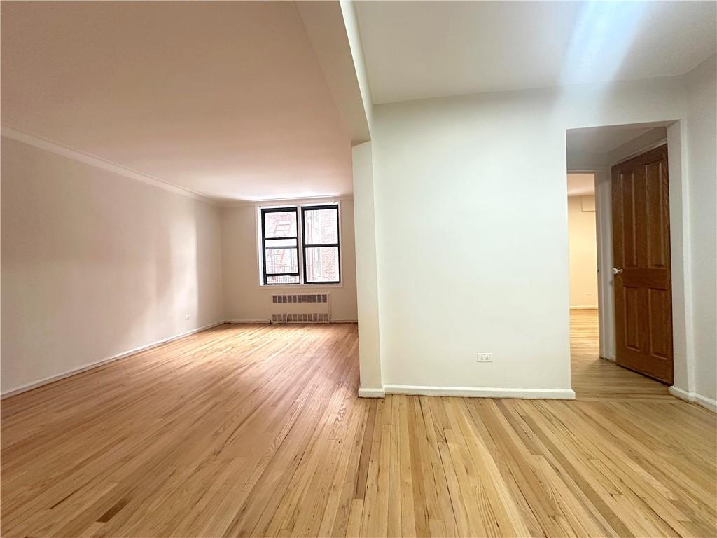3060 Ocean Avenue, Unit 2C Brooklyn, NY 11235 - Photo 4 of 20 an empty room with wooden floor and windows