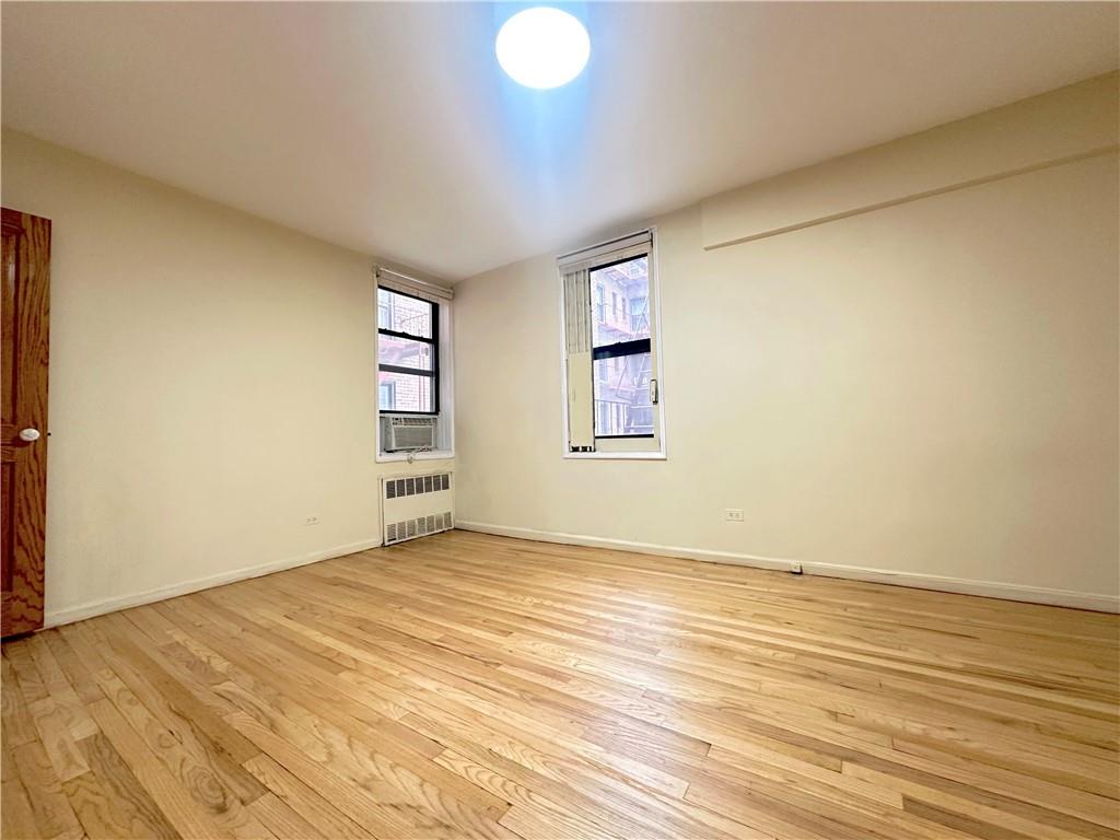 3060 Ocean Avenue, Unit 2C Brooklyn, NY 11235 - Photo 6 of 20 an empty room with wooden floor and windows