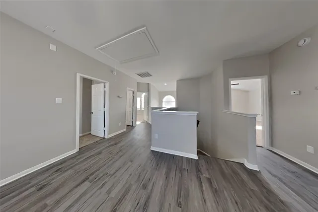 a view of a room with wooden floor and a kitchen