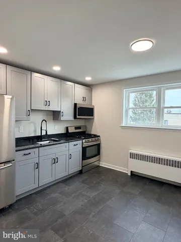 a kitchen with granite countertop white cabinets and stainless steel appliances
