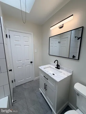 a bathroom with a sink a toilet and mirror