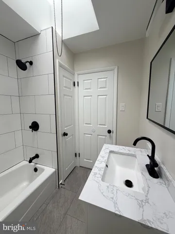 a bathroom with a tub sink a mirror and shower