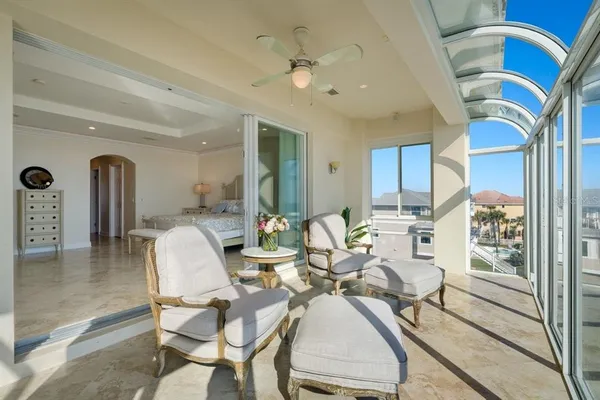 a living room with furniture a flat screen tv and a floor to ceiling window