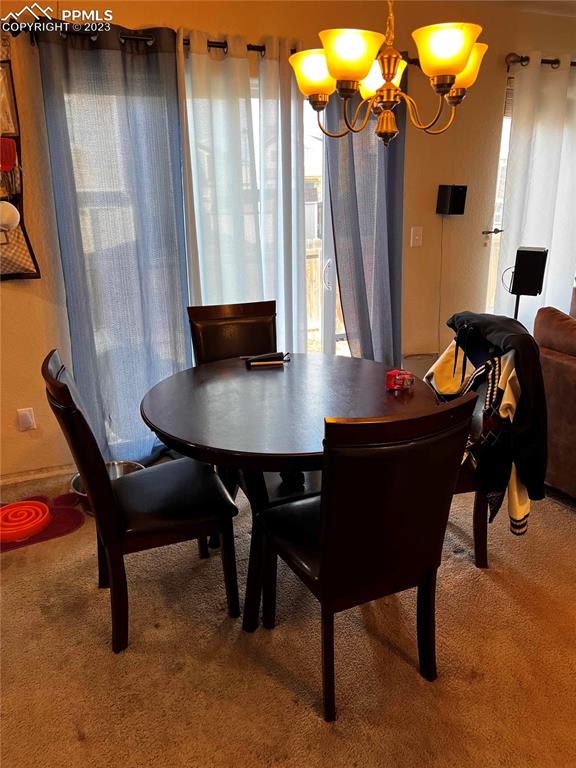6350 Dancing Moon Way Colorado Springs, CO 80911 - Photo 11 of 12 a view of a dining room with furniture and a chandelier