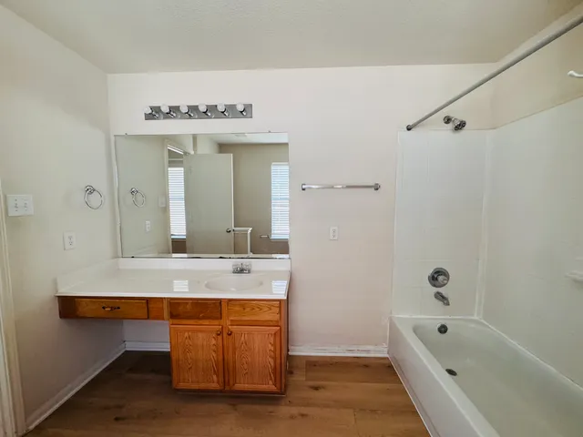 a spacious bathroom with a tub sink and mirror