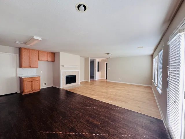 an empty room with wooden floor and fireplace