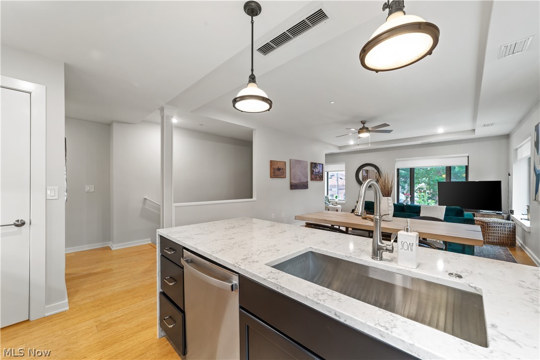 2044 Random Road, Unit 101 Cleveland, OH 44106 - Photo 12 of 44 Kitchen featuring ceiling fan, stainless steel dishwasher, light hardwood / wood-style floors, hanging light fixtures, and sink