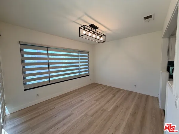 a view of a room with wooden floor and a window