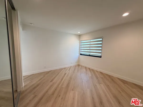 a view of a room with wooden floor and window