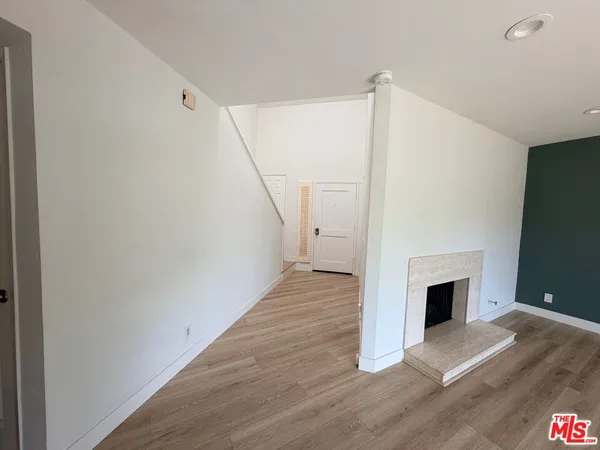 a view of a livingroom with wooden floor and a ceiling fan
