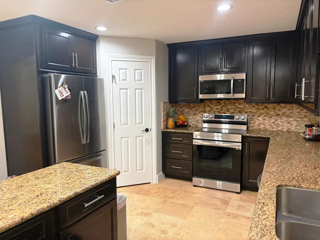 a kitchen with stainless steel appliances granite countertop a refrigerator stove and microwave