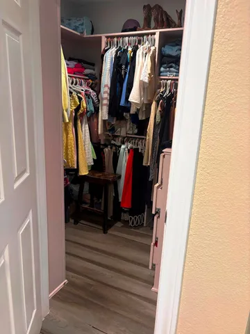 a view of walk in closet with clothes and shoes