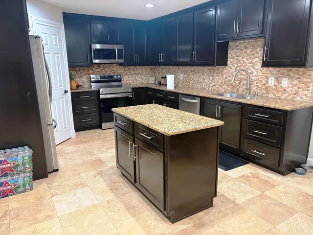 a kitchen with stainless steel appliances granite countertop a sink stove and refrigerator