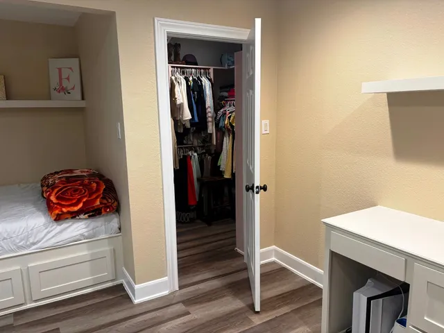 a bedroom with a bed a mirror and window