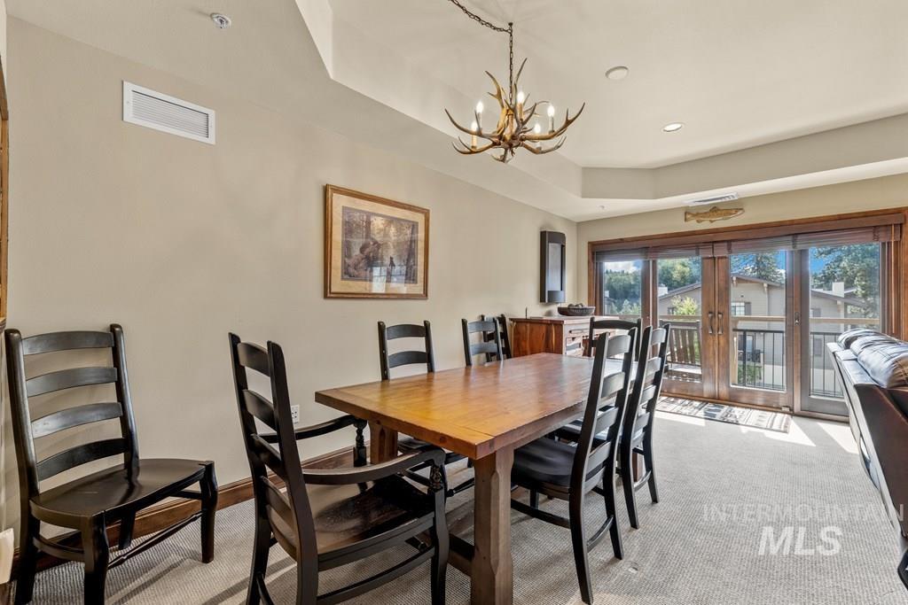 616 North 3rd Street, Unit 304 McCall, ID 83638 - Photo 13 of 38 Dining room with a raised ceiling, light carpet, recessed lighting, and a chandelier