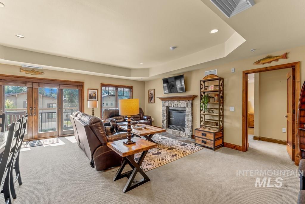 616 North 3rd Street, Unit 304 McCall, ID 83638 - Photo 19 of 38 Living area featuring french doors, light colored carpet, a stone fireplace, recessed lighting, and a raised ceiling