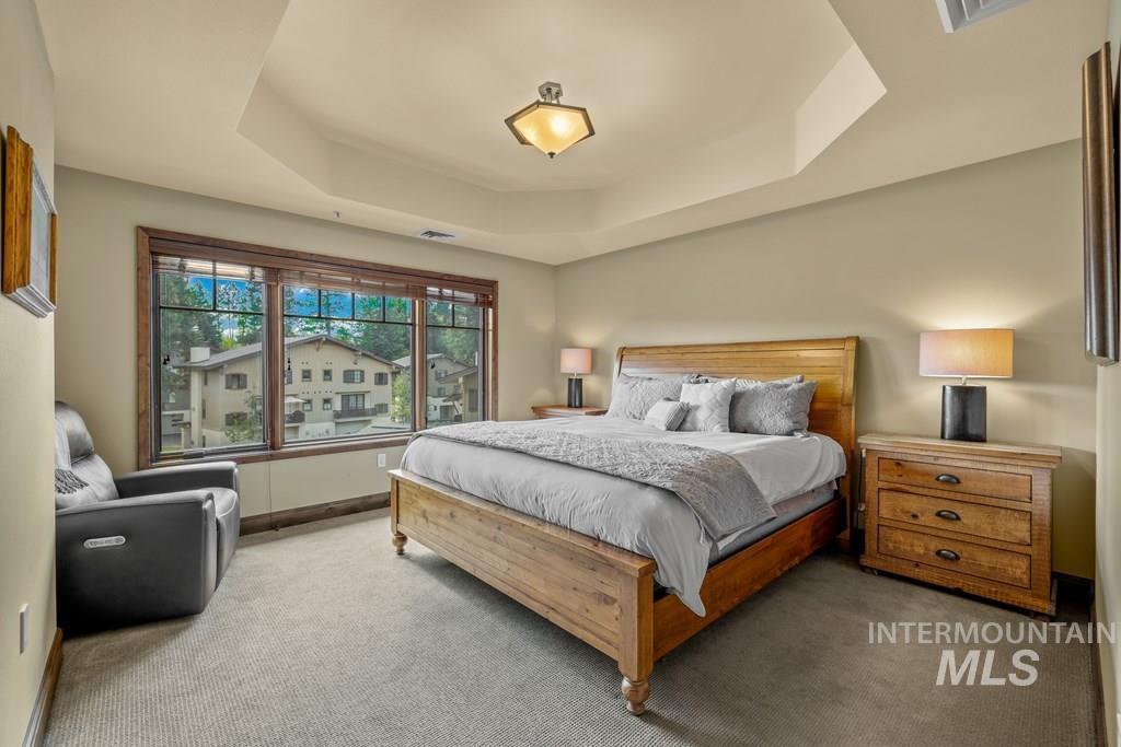 616 North 3rd Street, Unit 304 McCall, ID 83638 - Photo 24 of 38 Bedroom with a raised ceiling and carpetwith a walk-in closet and an ensuite bath.