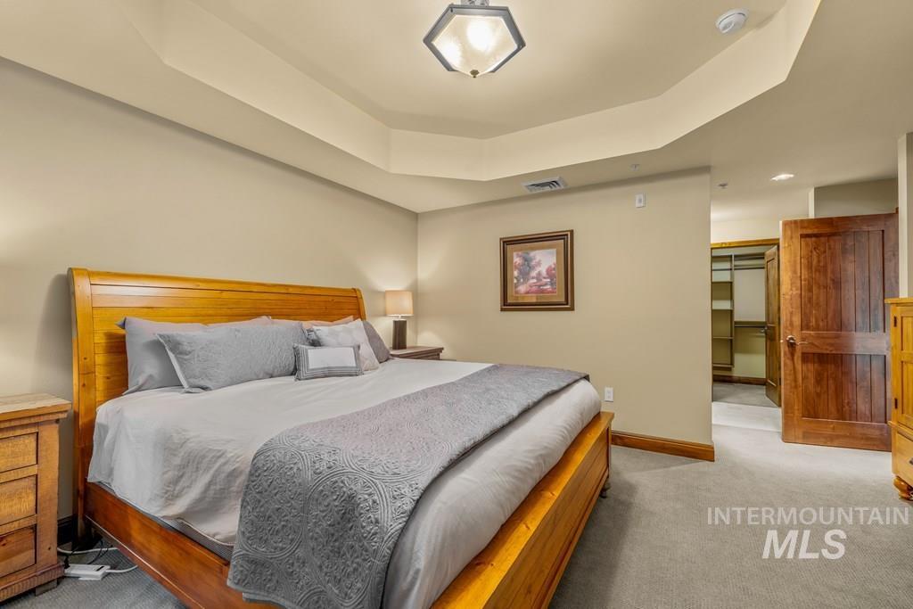 616 North 3rd Street, Unit 304 McCall, ID 83638 - Photo 26 of 38 Bedroom with light colored carpet, a tray ceiling, and a spacious closet