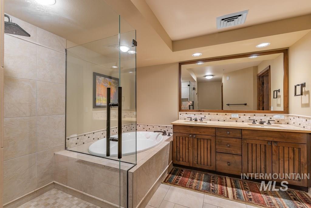 616 North 3rd Street, Unit 304 McCall, ID 83638 - Photo 27 of 38 Bathroom featuring double vanity, a bath, recessed lighting, tasteful backsplash, and light tile patterned flooring