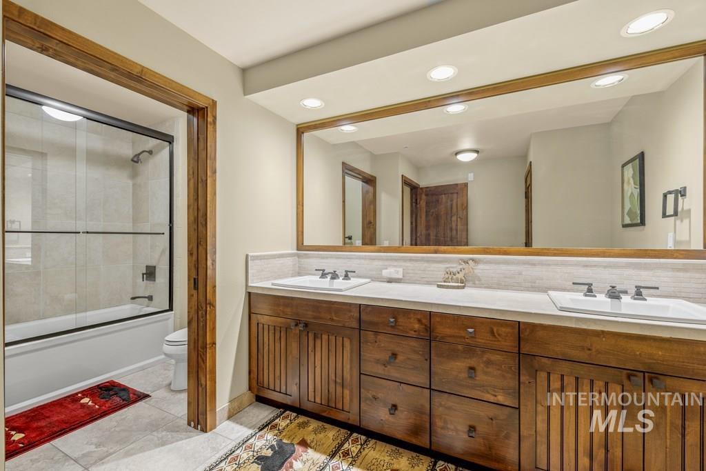 616 North 3rd Street, Unit 304 McCall, ID 83638 - Photo 35 of 38 Bathroom with enclosed tub / shower combo, tasteful backsplash, double vanity, recessed lighting, and light tile patterned flooring