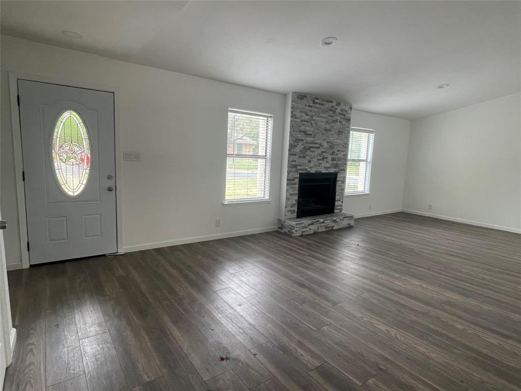 3 Ridge Drive Hickory Creek, TX 75065 - Photo 2 of 20 an empty room with wooden floor a fireplace and windows
