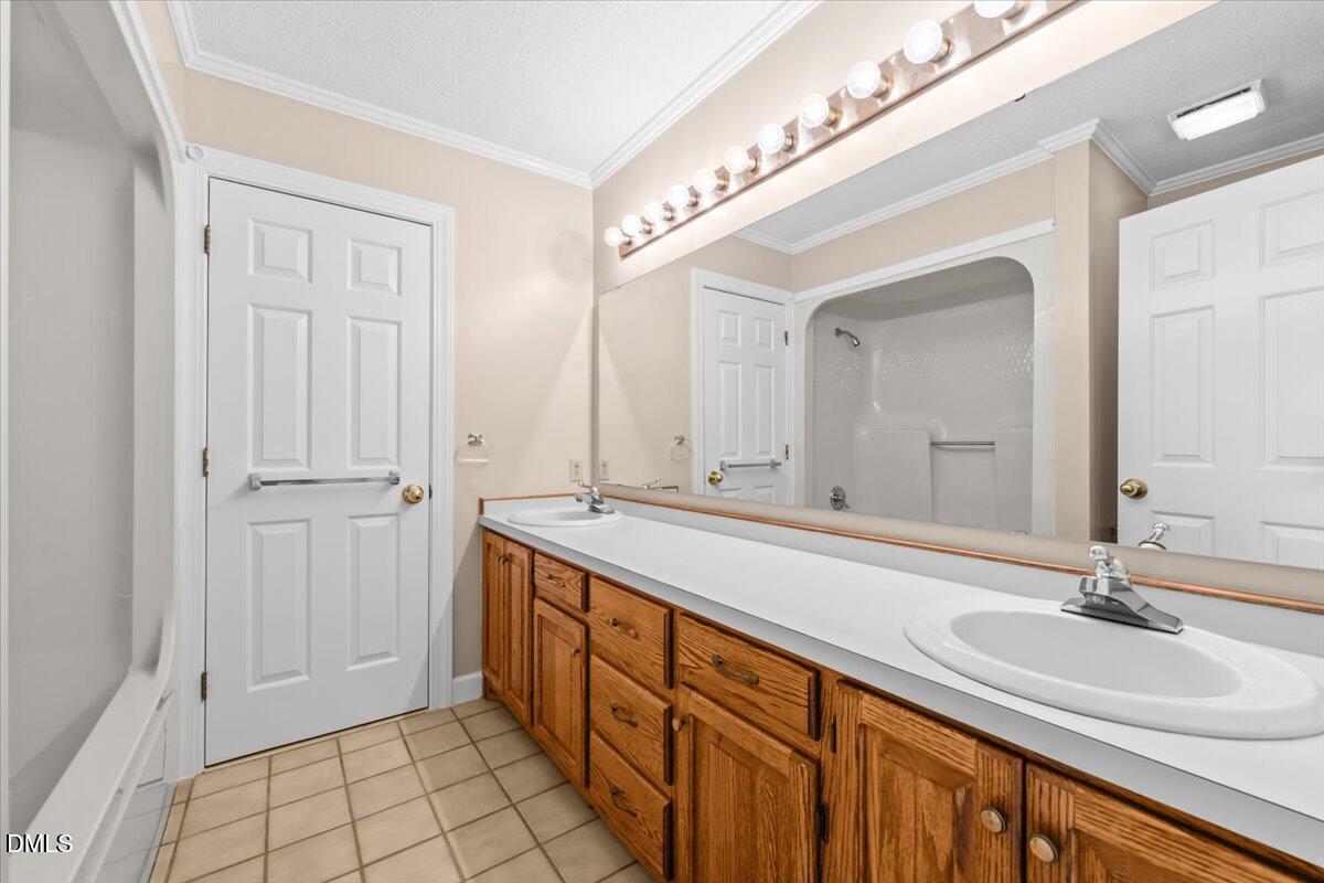6464 Bonlee Road Bear Creek, NC 27207 - Photo 33 of 82 a spacious bathroom with a double vanity sink and a mirror