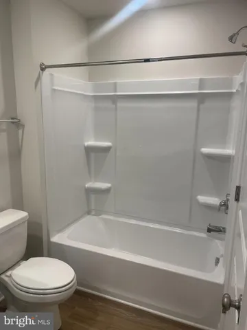 a bathroom with a toilet and a bath tub