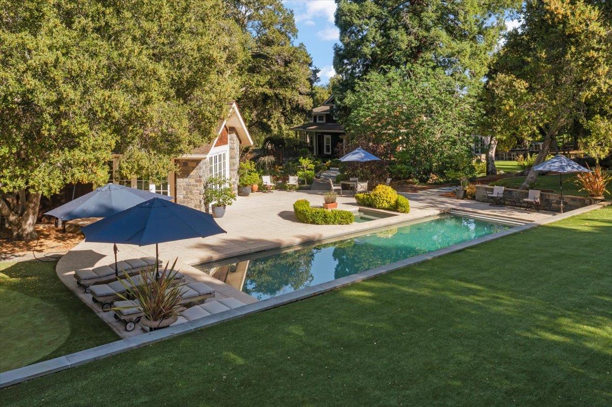 3510 Alpine Road Portola Valley, CA 94028 - Photo 70 of 77 a backyard of a house with table and chairs under an umbrella