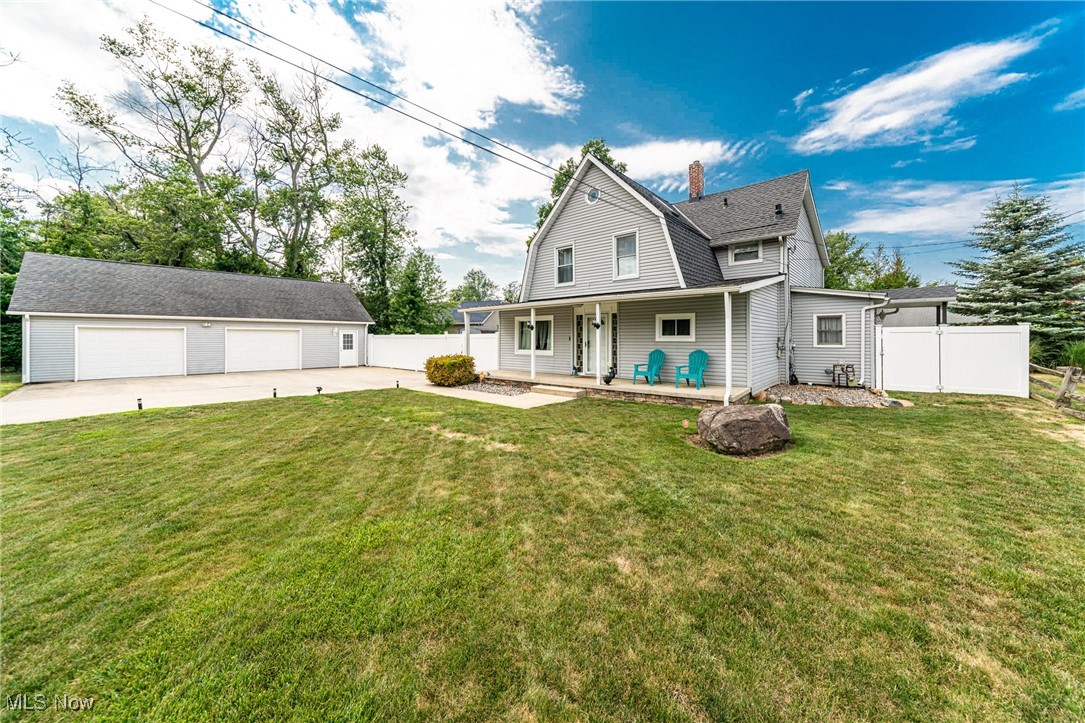 6873 Lake Road Madison, OH 44057 - Photo 2 of 29 View of front facade featuring a detached garage, an outbuilding, a gambrel roof, a patio, and a chimney