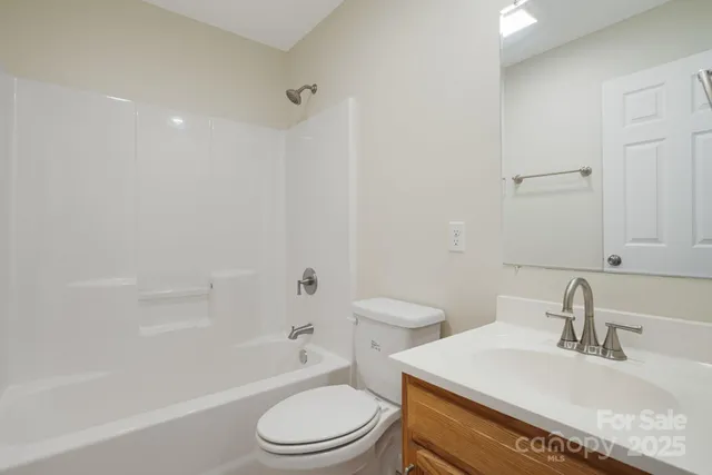 a bathroom with a toilet a sink a mirror a bathtub and vanity