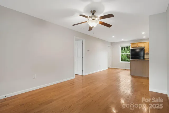 an empty room with ceiling fan and window