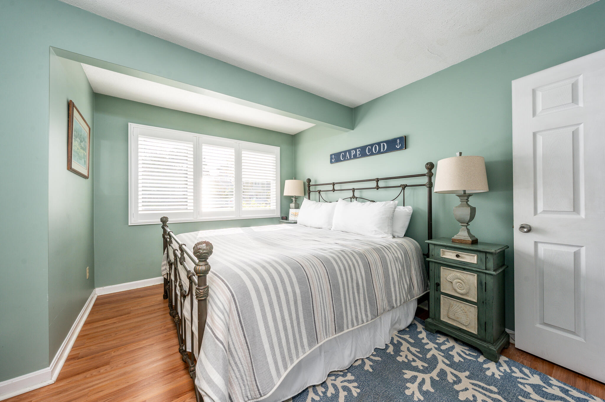 104 Howland Circle, Unit 104 Brewster, MA 02631 - Photo 16 of 29 a bedroom with a bed and wooden floor