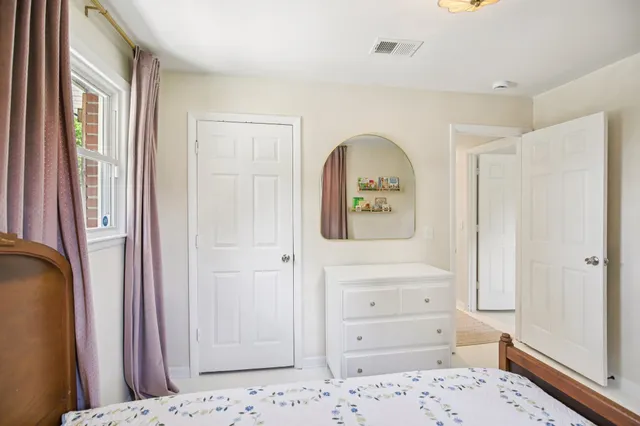 a spacious bedroom with a large bed couch and windows