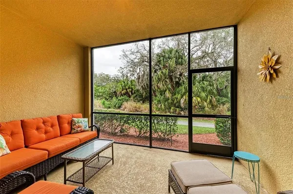 a living room with furniture and a floor to ceiling window