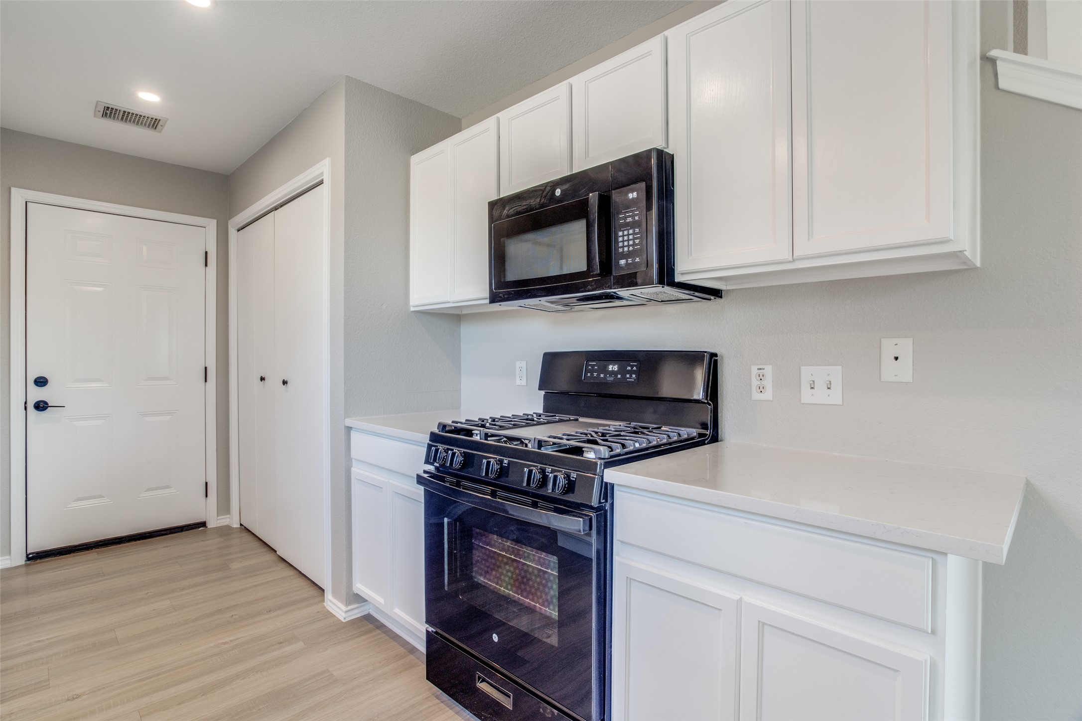 13145 Briarcreek Loop Manor, TX 78653 - Photo 12 of 25 a kitchen with stainless steel appliances granite countertop white cabinets and a stove top oven