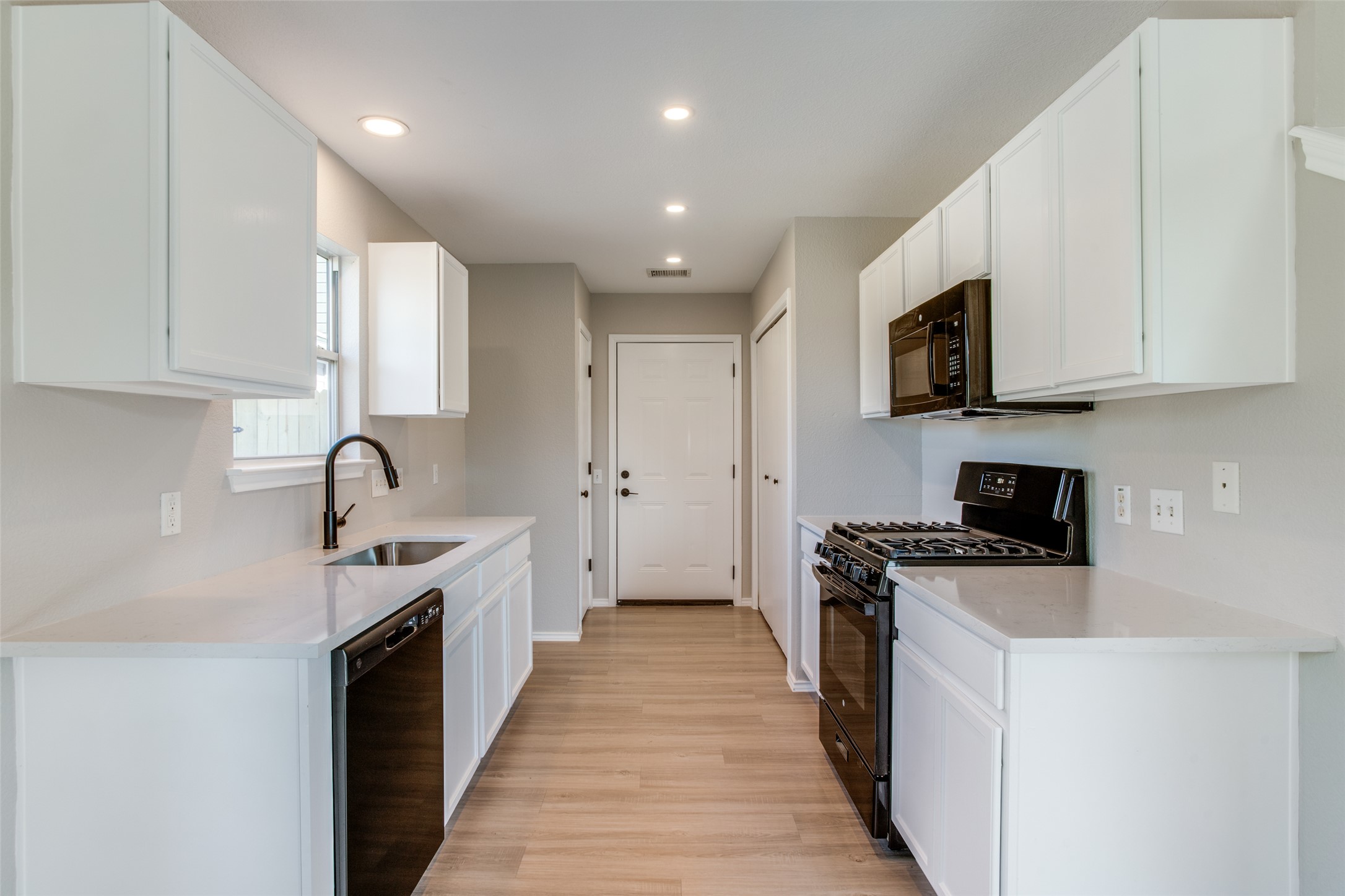 13145 Briarcreek Loop Manor, TX 78653 - Photo 15 of 25 a kitchen with a sink stove top oven and cabinets
