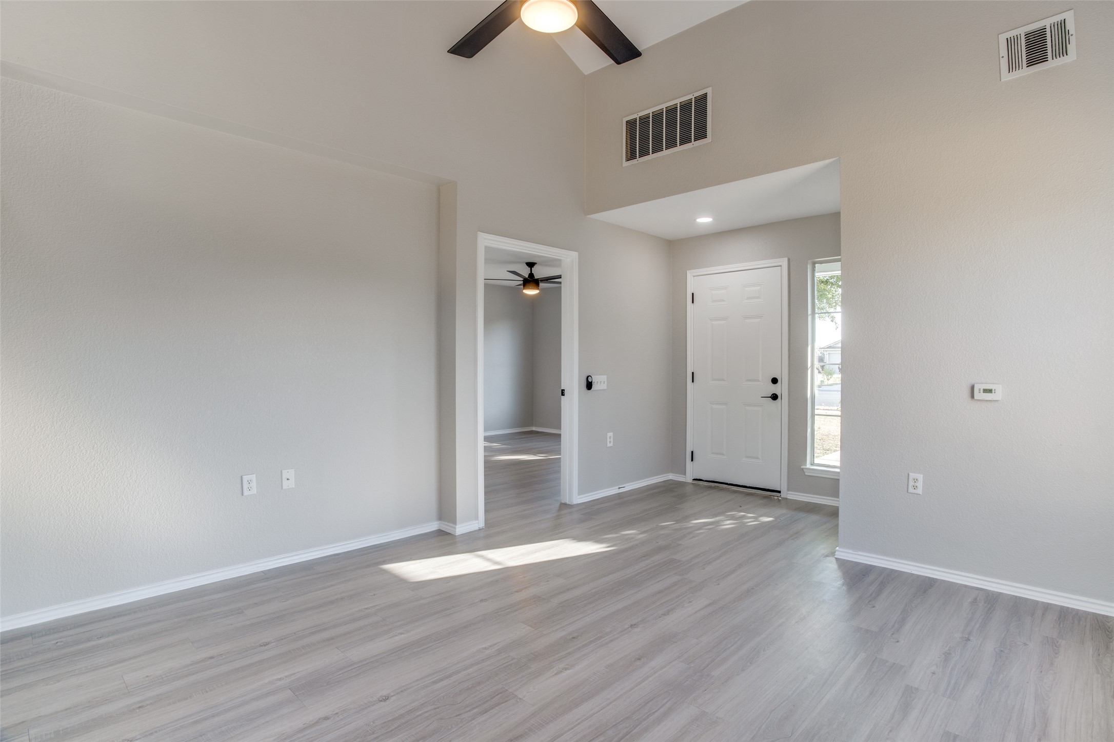 13145 Briarcreek Loop Manor, TX 78653 - Photo 5 of 25 an empty room with wooden floor and a ceiling fan