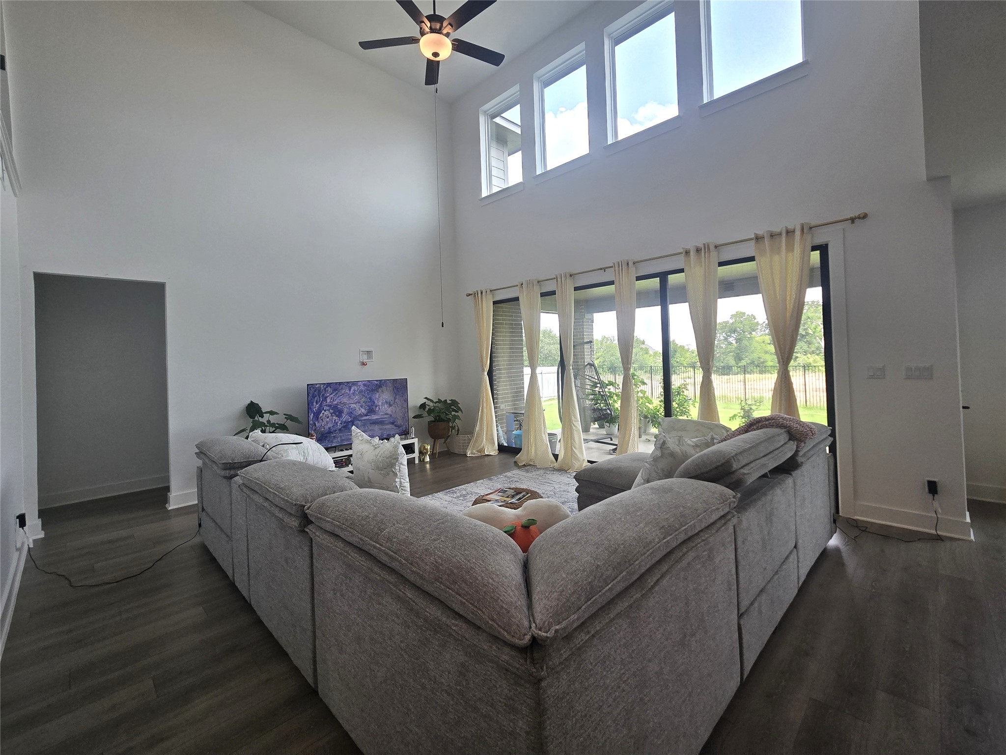 124 Ribera Drive Liberty Hill, TX 78642 - Photo 8 of 40 A grand living space features soaring ceilings and abundant natural light from large windows, creating an airy atmosphere.