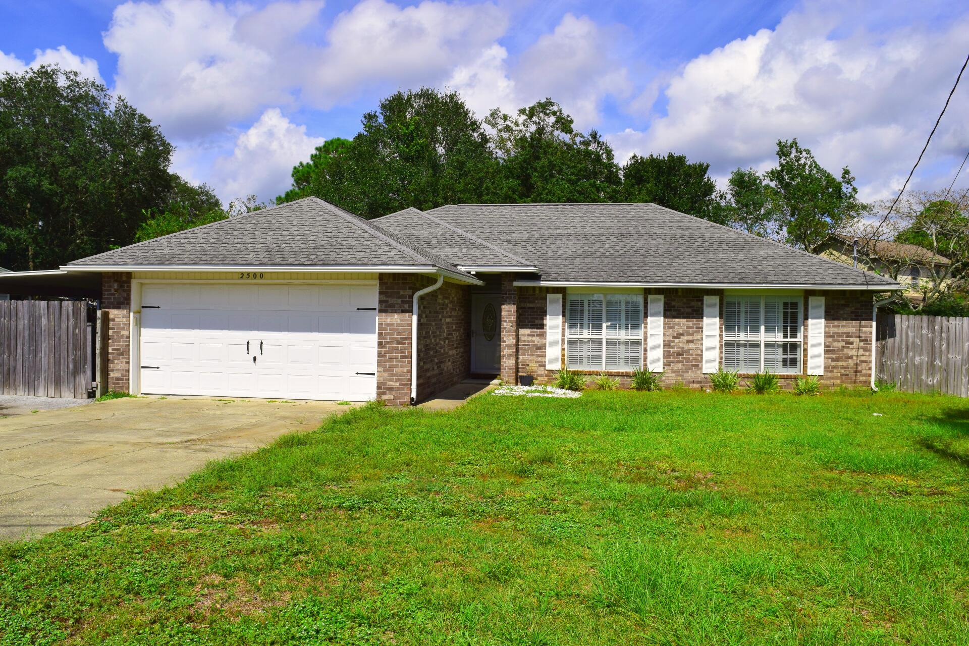 a front view of a house with a garden and yard