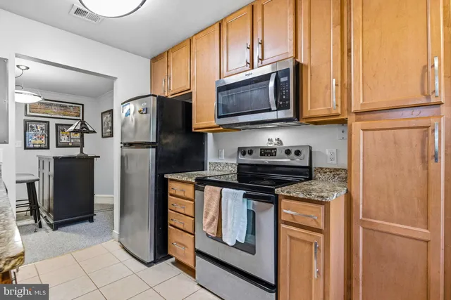 a kitchen with stainless steel appliances granite countertop a refrigerator stove and microwave