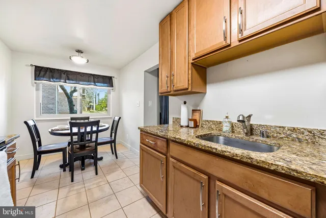 a kitchen with granite countertop a table chairs stove and cabinets