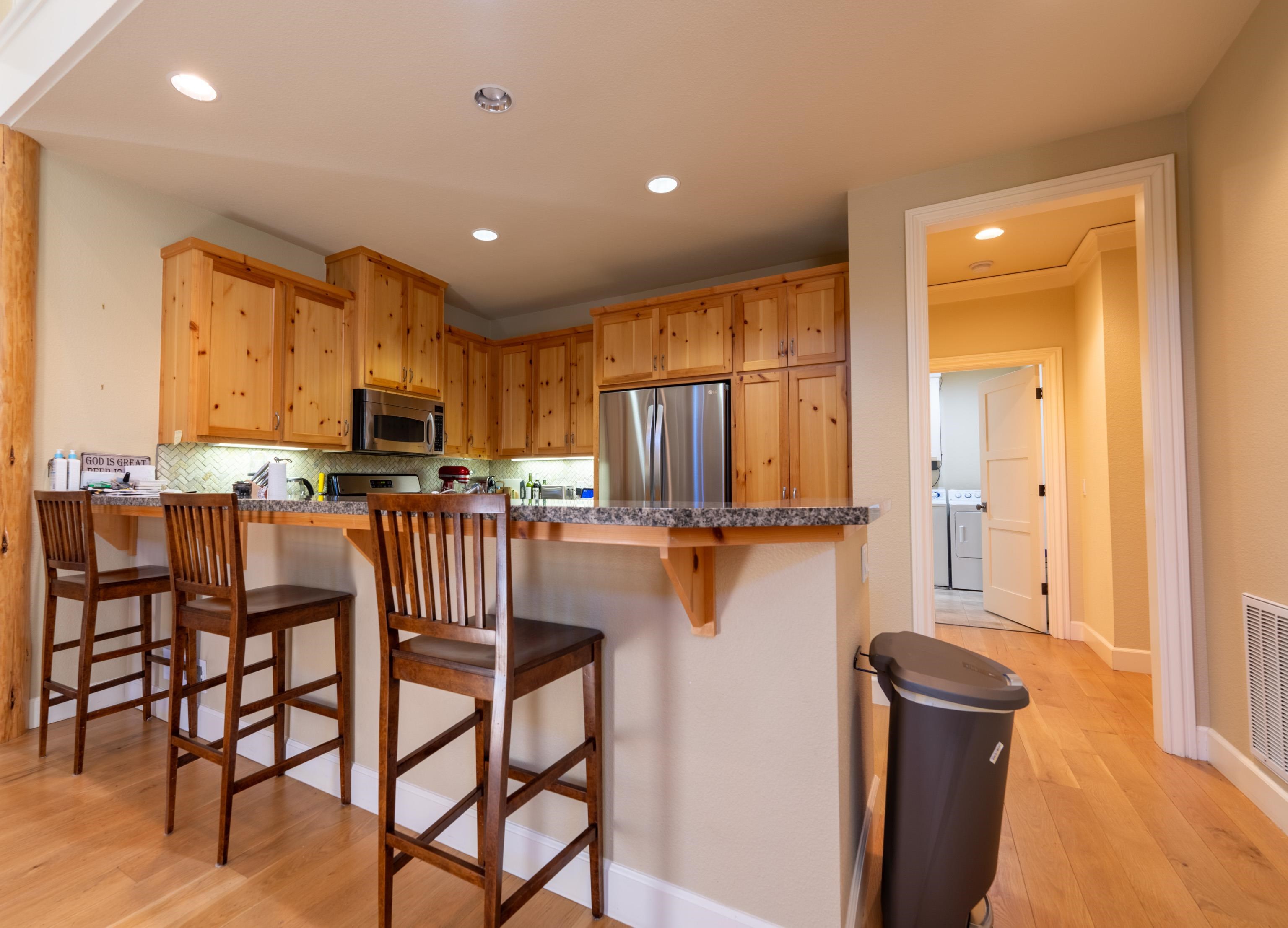 40 Hawk Ridge Clio, CA 96106 - Photo 11 of 42 a kitchen with stainless steel appliances kitchen island granite countertop a refrigerator a stove a microwave oven with white cabinets and wooden floor